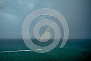 A Double Rainbow above the Surface of a Stormy Sea with a Rider on a Water Scooter