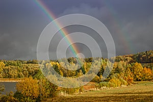 Double rainbow in countryside. Beautiful intense rainbow colors in rainy day.Weather forecast.Fall rural landscape with rainbow