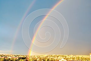 Double rainbow on dark blue stormy sky over Rivne town in Ukraine