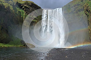 Double Rainbow and Dark Clouds at Powerful Skogafoss Waterfall, Katla Geopark, South Coast of Iceland