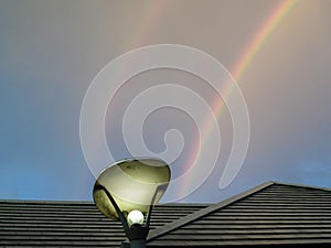 double rainbow on dark sky over roof