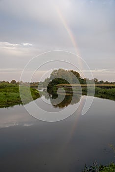 Double rainbow - one on the sky in a friend in the river