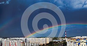 Double rainbow over city buildings after rain