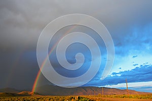 Double Rainbow Over Desert Landscape