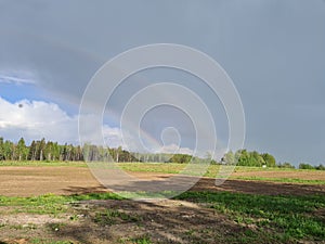 Double rainbow over a farm field