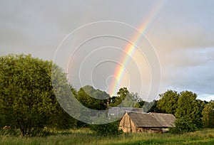 Double rainbow over the forest and houses at countryside.