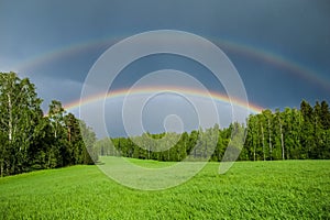 Double rainbow over a green grass meadow field