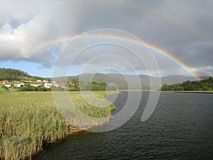 double rainbow over a meadow and a river