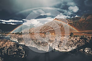 Double rainbow over river, mountains