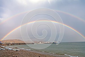 Double rainbow on sea beach