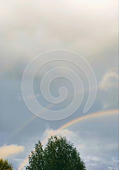 Double rainbow in the sky with clouds