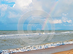 Double rainbow in the sky over the sea and waves