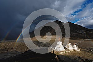 Double rainbows and overcast rainy sky and pagodas in Zanskar valley, India