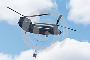 Double rotor, heavy airlift, military helicopter, in flight, carrying cargo.