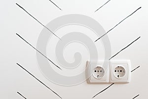 Double socket in plastic frame on wall background