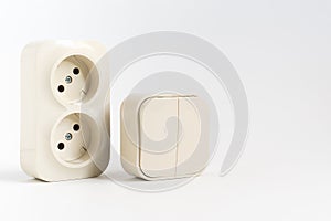 double socket and two-key light switch on white background.