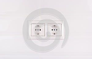 Double socket on white tile background. European electrical outlet