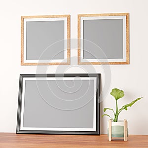 double thin wooden frames on wall and a dark large landscape photo frame