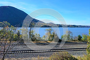 Double tracks next to Hudson River and mountain