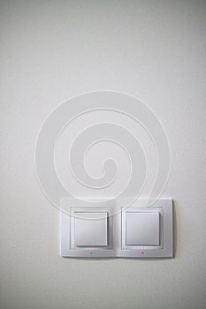 Electric two white lighting switchs on concrete wall