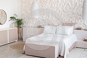 Double white soft comfortable bed, furniture, mirror and plant in light bedroom or minimalist modern hotel room