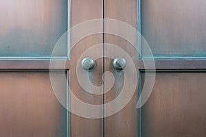 Double wooden door and old round brass knobs