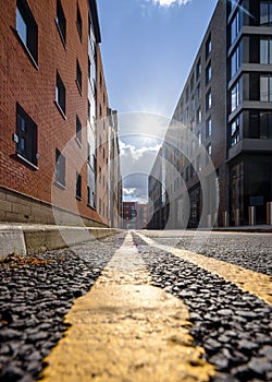 Double yellow lines on deserted street. Parking restrictions sunset with sun shining on tarmac road