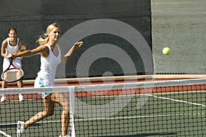 Doubles Player Hitting Tennis Ball With Backhand photo