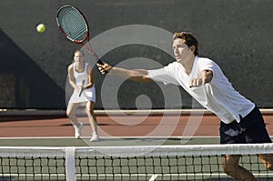 Doubles Player Hitting Tennis ball With Forehand