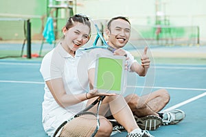 doubles tennis player sitting showing ipad screen to camera