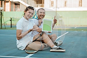 doubles tennis players with thumbs up showing ipad screen