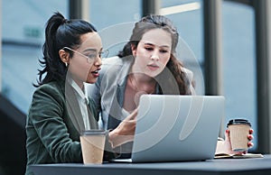 Doubling down to get it done. two young businesswomen using a laptop during a meeting at a coffee shop.