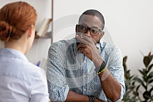 Doubtful african hr talking to caucasian applicant at job interview