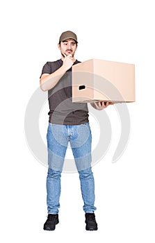 Doubtful delivery man, full length portrait, holding a cardboard box while keeps a hand under chin, isolated on white. Thoughtful