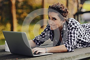 Doubtful expression of a woman with outdoor laptop