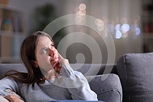 Doubtful pensive woman looking at side at home in the night