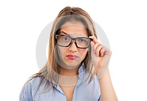 Doubtful woman looking at camera through eyeglasses