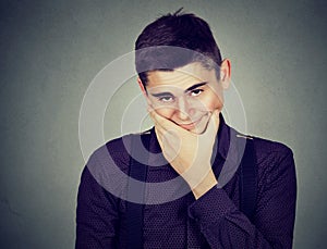 Doubtful young man posing at camera