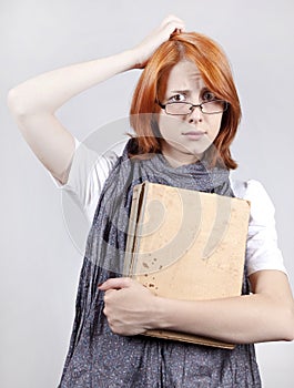 Doubting fashion girl in glasses with old book