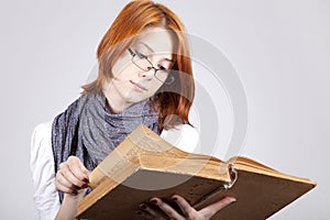 Doubting girl in glasses with old book