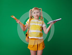 School girl choosing between sciences and art isolated on green photo