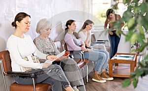 Doubting woman reading papers in lobby of medical facility