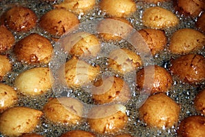 Dough balls in boiling oil, a street stall selling donuts