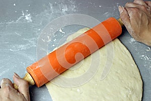 Dough circle with a rolling pin on the table