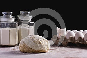 Dough on a dark background with ingredients