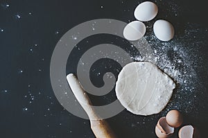 Dough preparation. Baking ingredients: egg and flour on black background