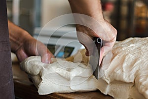 Dough preparation and kneading at baking sheet table in the oven multigrain white flour sesame seeds grain bread person baker cutt