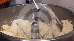 Dough preparing,  kneading process in factory. Industrial mixer for kneading dough.