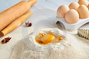 Dough recipe ingredients and accessories on the gray table: eggs, flour, spices and bakewares. Baking background