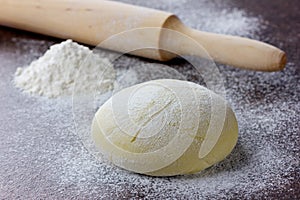 Dough with rolling pin and flour photo